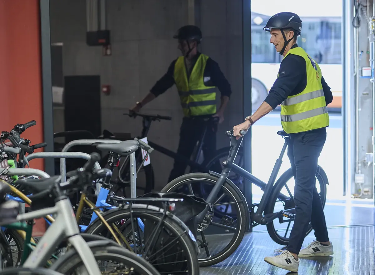 Homme avec bicyclette au support à vélos